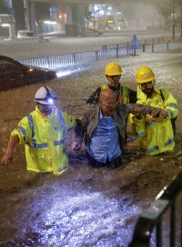 Pracovníci kanalizace pomáhají řidiči dostat se na bezpečné místo