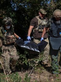 Ukrajinští vojáci nesou pytel s tělem mrtvého ruského vojáka uprostřed ruského útoku na Ukrajinu v obci Blahodatne v Doněcku