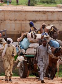 Čadští majitelé vozíků převážejí při přejezdu hranice mezi Súdánem a Čadem v Adre věci Súdánců, kteří uprchli před konfliktem v súdánském Dárfúru