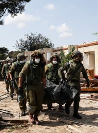 Vojáci odnáší těla obětí v kibucu Kfar Aza, kde podle zpravodajského webu The Times of Israel Hamás v sobotu zavraždil 70 izraelských civilistů.