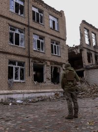 Ukrajinský policista před zničeným domem v Avdijivce