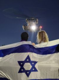 Lidé s izraelskou vlajkou vyhlížejí v Tel Avivu přílet vrtulníku s propuštěnými rukojmími