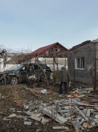 Obyvatelé Oděsy odstraňují trosky z dvorku svého domu, který byl poškozen během ruského dronového útoku 17. prosince 2023