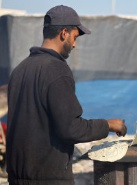 Muži v uprchlickém táboře pečou chléb