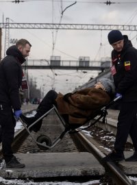 Dobrovolníci nevládní organizace Východ SOS pomáhají ženě nastoupit do evakuačního vlaku v ukrajinském Pokrovsku po zesílení ruských raketových úderů v okolí Avdijivky