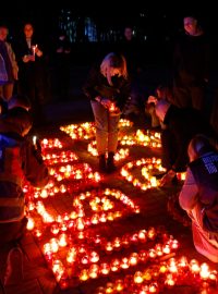 Lidé zapalují svíčky před budovou koncertní síně v Krasnogorsku