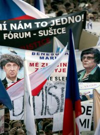 Portréty premiéra Babiše a ministryně Benešové mezi protestními transparenty.