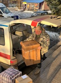 Čeští humanitární dobrovolníci Alois Zwesper a Petr Drápal otevírají dvě dodávky napěchované až po střechu pomocí