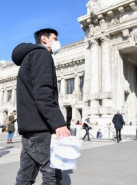 Pouliční obchodník prodává roušky před hlavním nádražím v Miláně