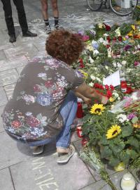 Žena pokládá květinu před místem útoku v Hamburku.