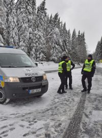 Policisté hlídkují u abertamské křižovatky nad Jáchymovem, kde silničáři uzavřeli sněhem zavátou silnici směrem na Boží Dar