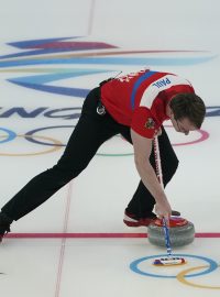 Zametající Tomáš Paul v curlingovém utkání na olympiádě v Pekingu