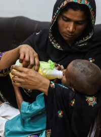 Matka krmí svého HIV pozitivního syna, zatímco čekají na vyšetření na klinice ve městě Rato Dero