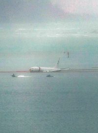 Vojenské letadlo je vidět v mělkých vodách zálivu Kaneohe poté, co sjelo z konce přistávací dráhy na základně námořní pěchoty na Havaji v Kaneohe 20. listopadu 2023. Letoun je Boeing P8 Poseidon, popisovaný jako vojenský pozorovací a hlídkový letoun. Stav posádky není znám