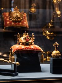 České korunovační klenoty sloužily jako odznaky vlády a moci českých králů. Souprava zahrnuje Svatováclavskou korunu, královské žezlo, královské jablko, kožená pouzdra na ně, podušku pod korunu a korunovační plášť s doplňky
