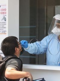 Obyvatel Tchaj-wanu podstupuje antigenní test ve stánku u letiště v Tchaj-peji