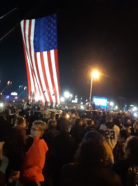 Během projevu Joea Bidena panuje ve Wilmingtonu slavnotní atmosféra. Na plotě visí balonky, dva jeříby drží velkou vlajku USA
