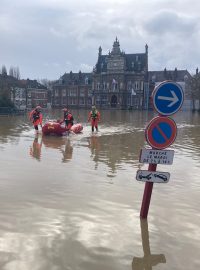 Záchranáři evakuují starší ženu v zatopené obci Arques na severu Francie