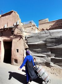Žena prochází před zničeným domem v Marrákeši